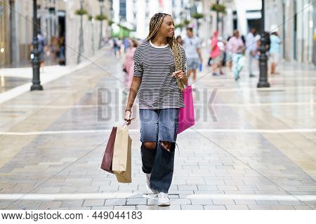 Young Black Woman, With Coloured Braids, With Shopping Bags In The Street.
