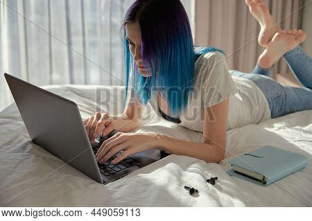 Serious Woman With Blue Hair In Bedroom Work With Laptop.
