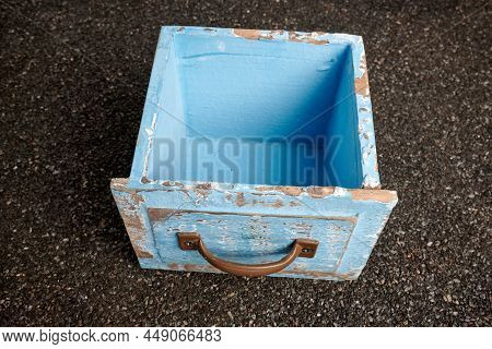 Old Blue Wood Box On Ruberoid Textured Surface. Empty Rustic Wooden Box. Wood Container With Bronze 