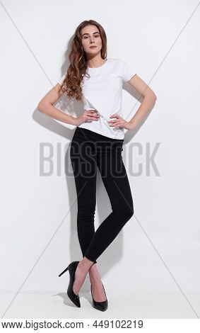 Studio Fashion Shot: Portrait Of A Lovely Young Girl In Black Jeans And White T-shirt. Model Test