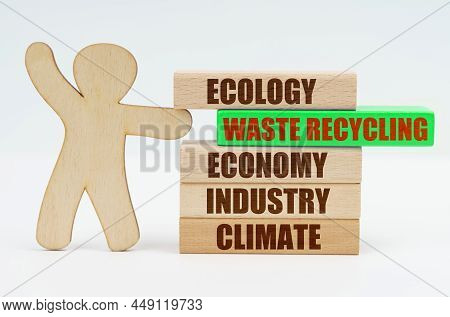 Ecology And Industry Concept. The Wooden Man Moves The Green Block With The Inscription - Waste Recy