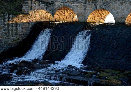 The Dam Of The Breeding Fish Pond Has A Canal Safety Overflow Similar To A Weir. The Water Flows Und