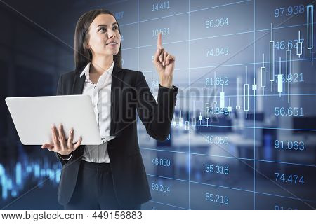 Attractive Happy European Businesswoman Using Laptop In Blurry Office Interior With Glowing Forex Ch