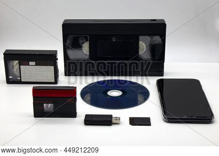 Evolution Of Media Storage Device On White Background. Vintage Technology From The 90s Until Today.