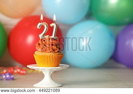 21th Birthday, Coming Of Age Party. Delicious Cupcake With Number Shaped Candles On Wooden Table, Sp