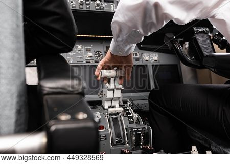 Cropped View Of Co-pilot Using Thrust Lever In Airplane Simulator