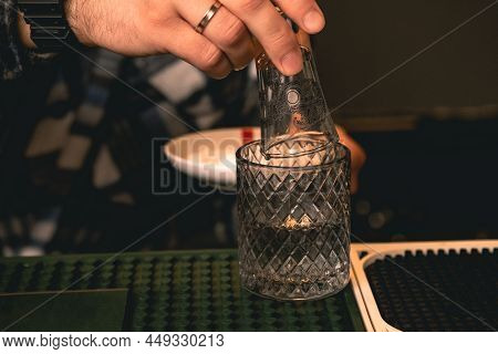 Man Dipping Glass Into Water Before Dipping In Salt For Serving Tequila