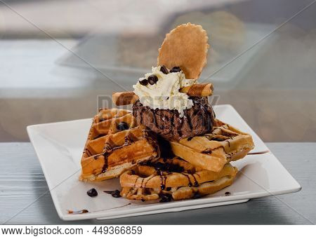 Belgian Waffles With Ice-cream  And Chocolate On White Plate On The Table In A Cafe