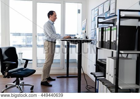 Adjustable Height Desk Stand In Office Using Computer