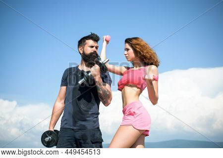 Fit Couple Doing Exercising Outdoors With Dumbbell. Sportive Woman And Man, Team. Sport, Dumbbell An