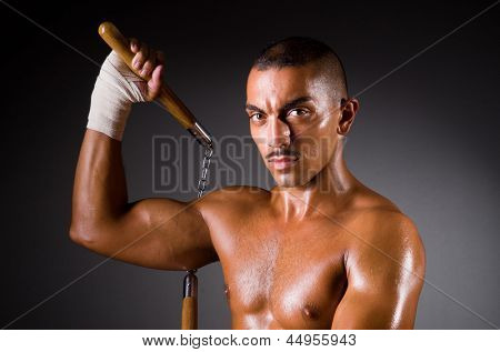 Muskuløs mand med nunchucks på hvid
