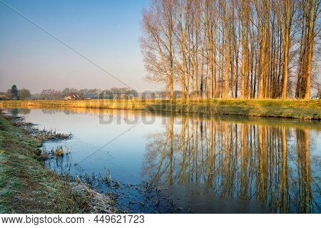 Row Of Trees Reflecting In The River Berkel Close To The Dutch City Lochem In The Province Gelderlan