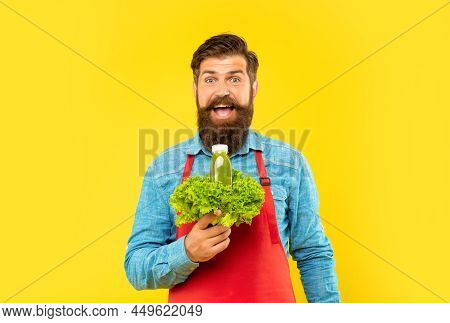 Surprised Man In Apron Holding Fresh Lettuce And Juice Bottle Yellow Background, Juice Barkeeper