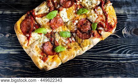 Pinsa With Meat, Vegetables And Herbs On A Wooden Background Close-up. Baking Homemade Pinsa.