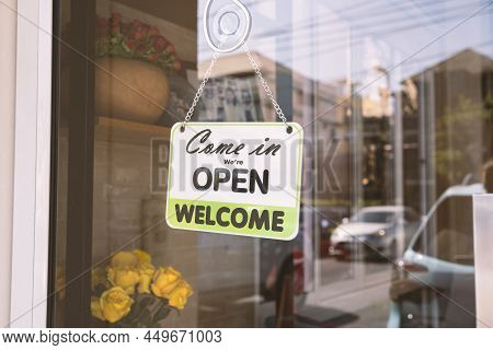 Open Sign Broad Through The Glass Of Door In Cafe. Business Service And Food Concept. Vintage Tone F