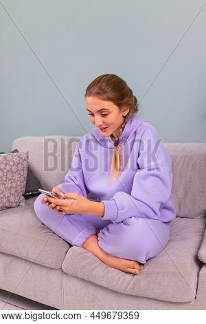 Happy Smiling Teenage Girl With Her Smartphone Browsing Social Newtwork, Communicating Relaxed On A