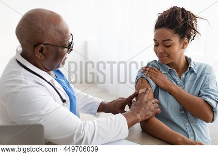 Pregnant Black Lady Getting Vaccinated, Doctor Applying Adhesive Bandage