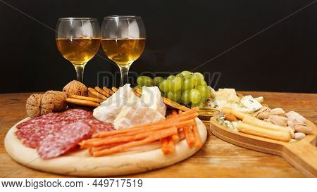 Cheese Platter With Assorted Cheeses, Grapes, Nuts Over Black Background. Italian Cheese Platter For