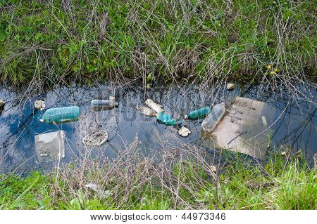 Konzept oder konzeptionelle unhygienischen verschmutzten Fluss, Abwasser oder schmutziges Wasser und Gras mit Abfall, Müll und