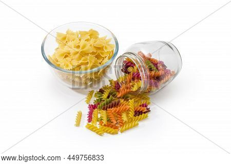 Raw Bow-tie Pasta In A Glass Bowl And Spiral Pasta Colored By Beetroot, Spinach, Paprika, Carrot, Gr
