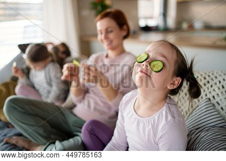 Little Chidlren With Mother Putting Cucumber On Faces At Home.