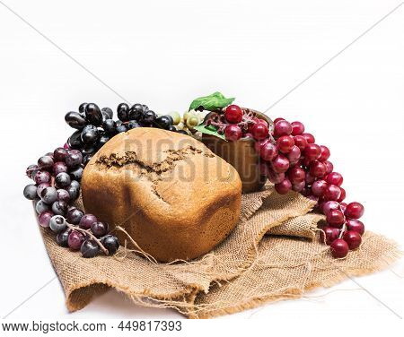 A Loaf Of Coarse Rye Homemade Bread With A Cracked Toasted Crust And Bunches Of Red, Black And Green