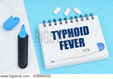 Medical Diagnosis Concept. On A White-blue Surface Are Pills, A Thermometer, A Marker And A Notebook