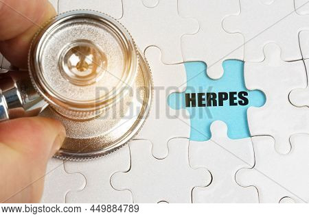Medical Concept. On Puzzles A Hand With A Stethoscope, On A Blue Background The Inscription - Herpes