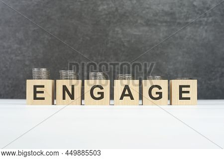 Engage Word, Text Written On Wooden Cubes On A Black Background With Coins On Cubes