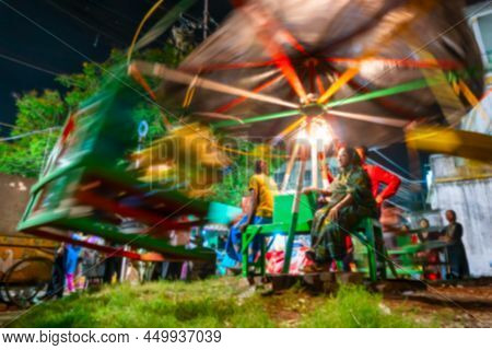 Blurred Image Of Howrah, West Bengal, India. Aged Woman Watching Over Children Riding On Nagordola- 