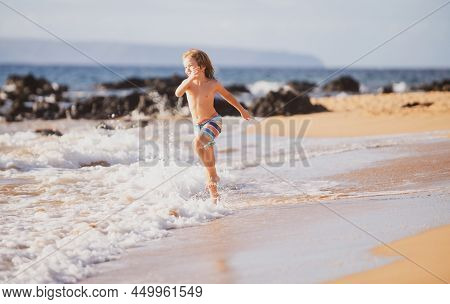 Child Running Through Water Close To Shore Along The Sea Beach. A Boy Runs Along The Sea Coast. Rest
