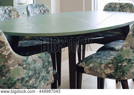 A Fragment Of A Green Wooden Dining Table And Upholstered Chairs In A Modern Style. Furniture Design