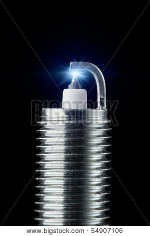 working spark plug with blue sparkle, isolated on black