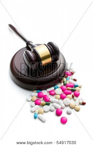 judge's gavel with pills on white background