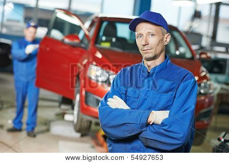Portrait of repairman auto mechanic in front of automobile bodywork repair shop service station