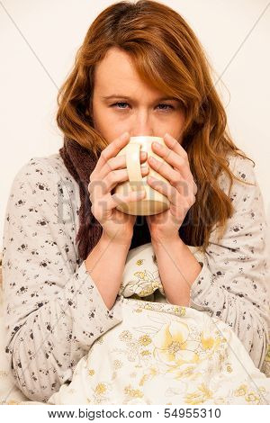 Ill Woman With Feaver Drinking Cup Of Warm Tea Under Blanket
