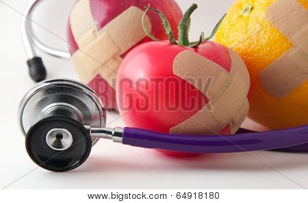 Closeup Bandaged Apple, Tomato, and Orange with Stethescope