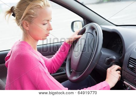 Female car driver starting the engine.