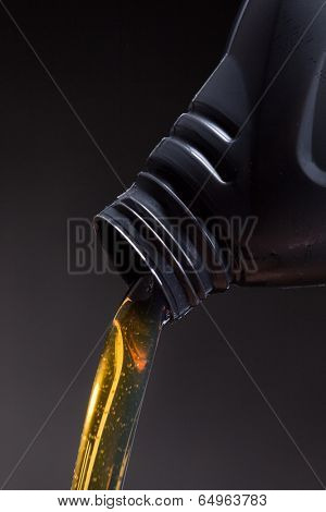 Motor oil pouring over black background