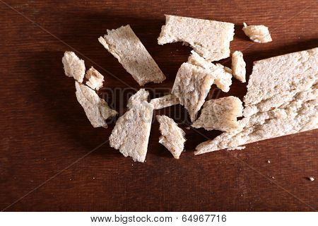 Crushed dietic rye bread on wooden background