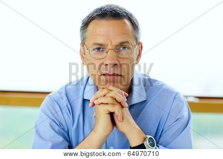 Senior man in glasses looking at camera