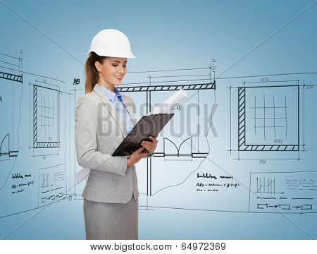building, developing, consrtuction and architecture concept - friendly young smiling architect in white helmet with blueprint and clipboard