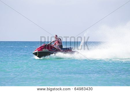 Young guy cruising on a jetski on the caribbean sea