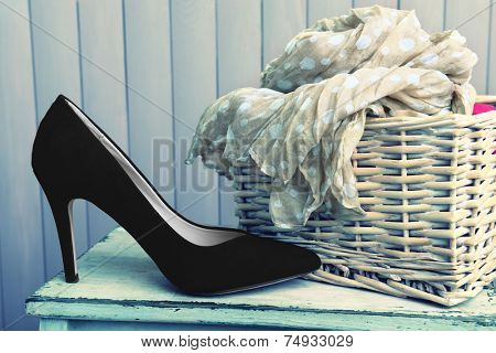 Black women shoes and scarf on bench on wooden background