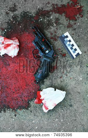 Gun and blood at crime scene 