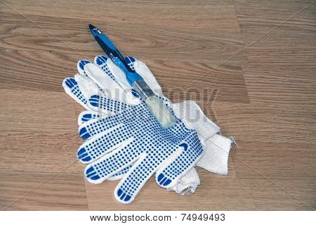 A Pair Of Gloves And A Brush With Paint