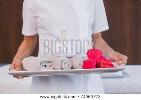 Close up mid section of female masseur holding rolled up towels