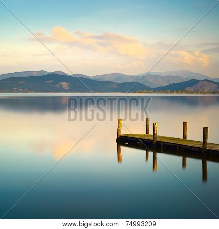 Wooden Pier Or Jetty And On A Blue Lake Sunset And Sky Reflection On Water. Versilia Tuscany, Italy
