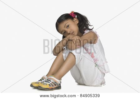 Portrait of a girl resting her face on her knees