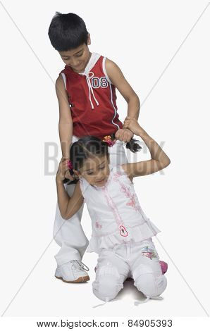 Boy pulling hair of his sister